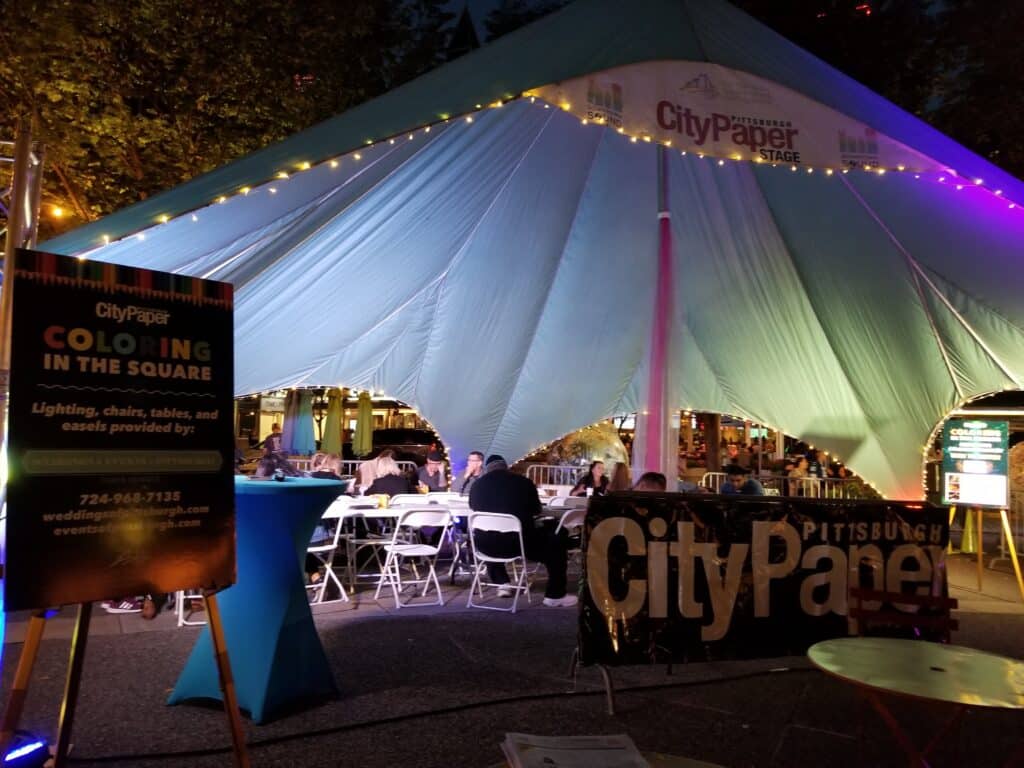 a large tent with tables and chairs under it