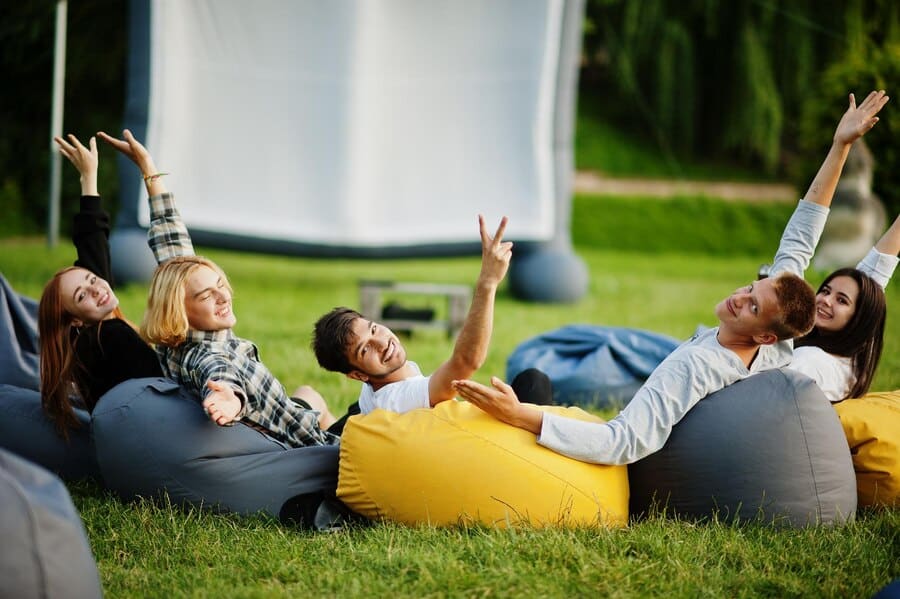 a group of people laying on bean bags in the grass