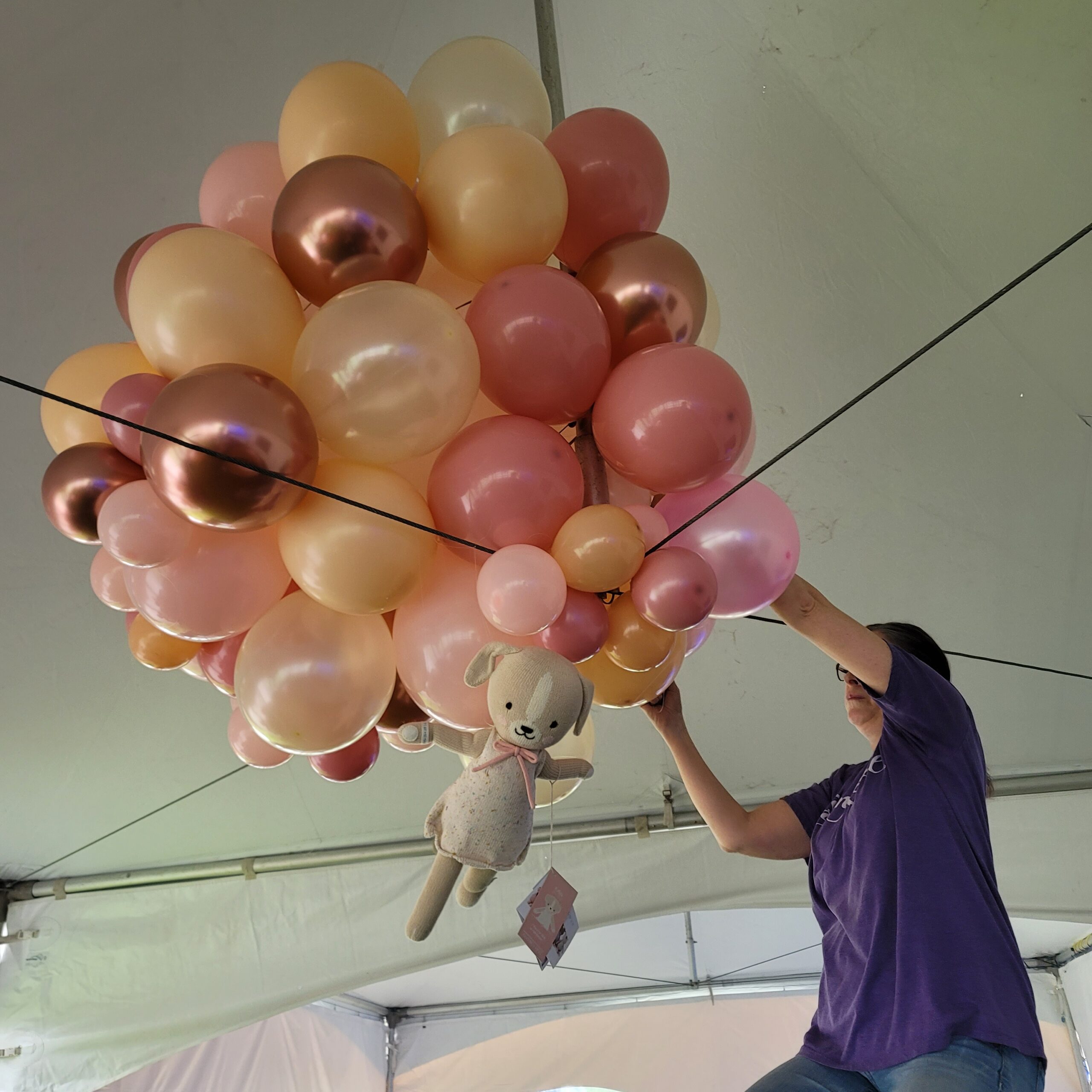 a woman is holding balloons in the shape of animals