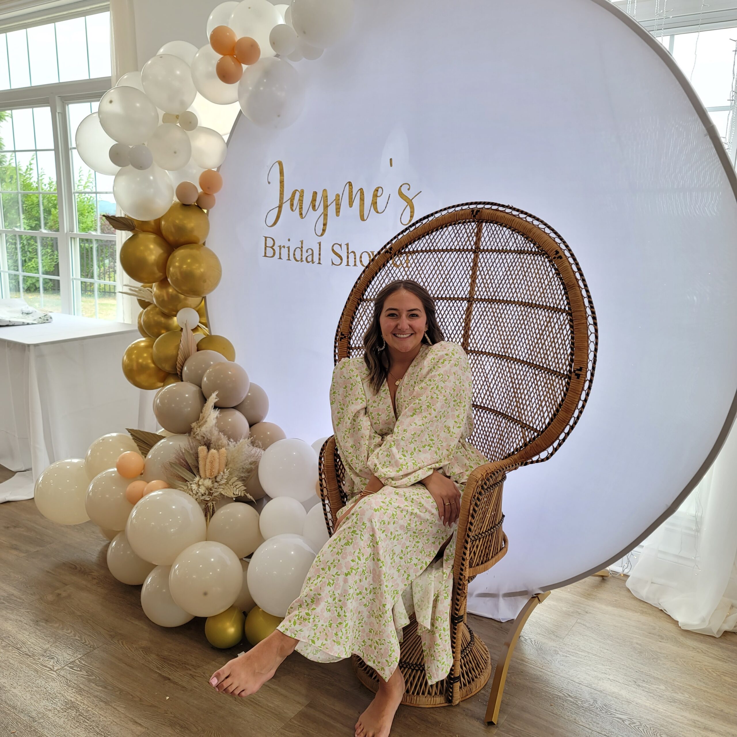 a woman in a white dress is standing on a chair with balloons