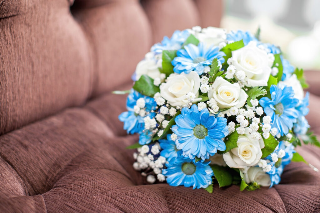 a bouquet of blue and white flowers on a couch
