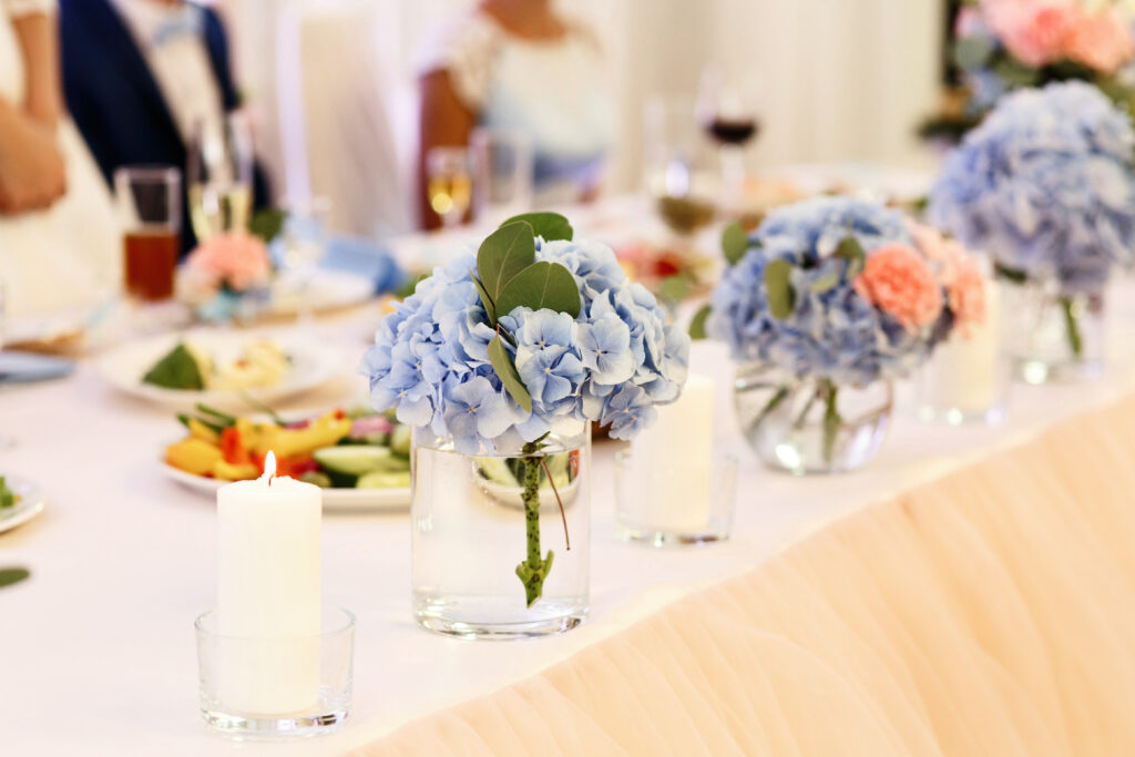 a table topped with vases filled with blue flowers