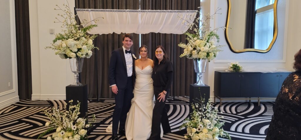 a man and woman standing in front of a wedding arch