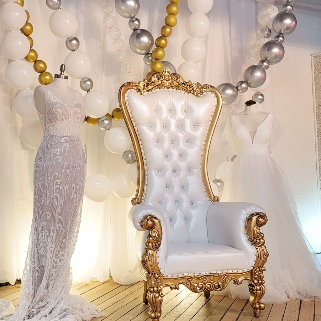 a white throne sitting in front of a balloon arch