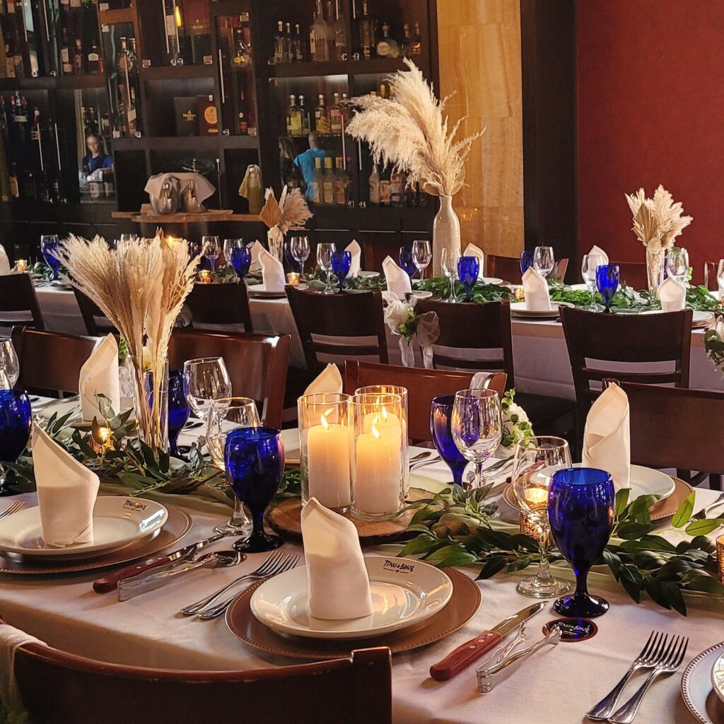 a table set for a formal dinner with candles and rattan centerpieces