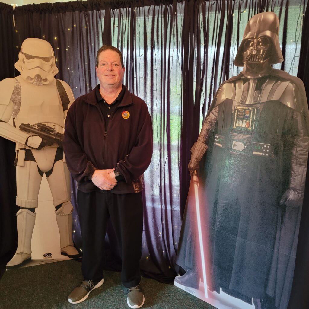 a man standing in front of a display of star wars characters