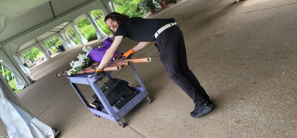a woman in black shirt holding a wooden stick
