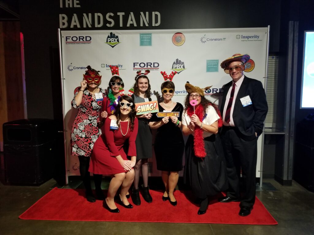 a group of people standing on a red carpet at a holiday party
