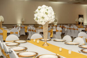 a tall vase with white flowers on top of a table