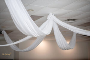 a room with white drapes hanging from the ceiling