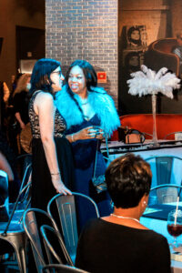 two women standing next to each other at a party