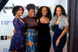 three women standing next to each other on a red carpet