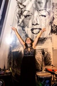 a woman standing in front of a large poster