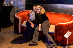 two women sitting on a couch in a room