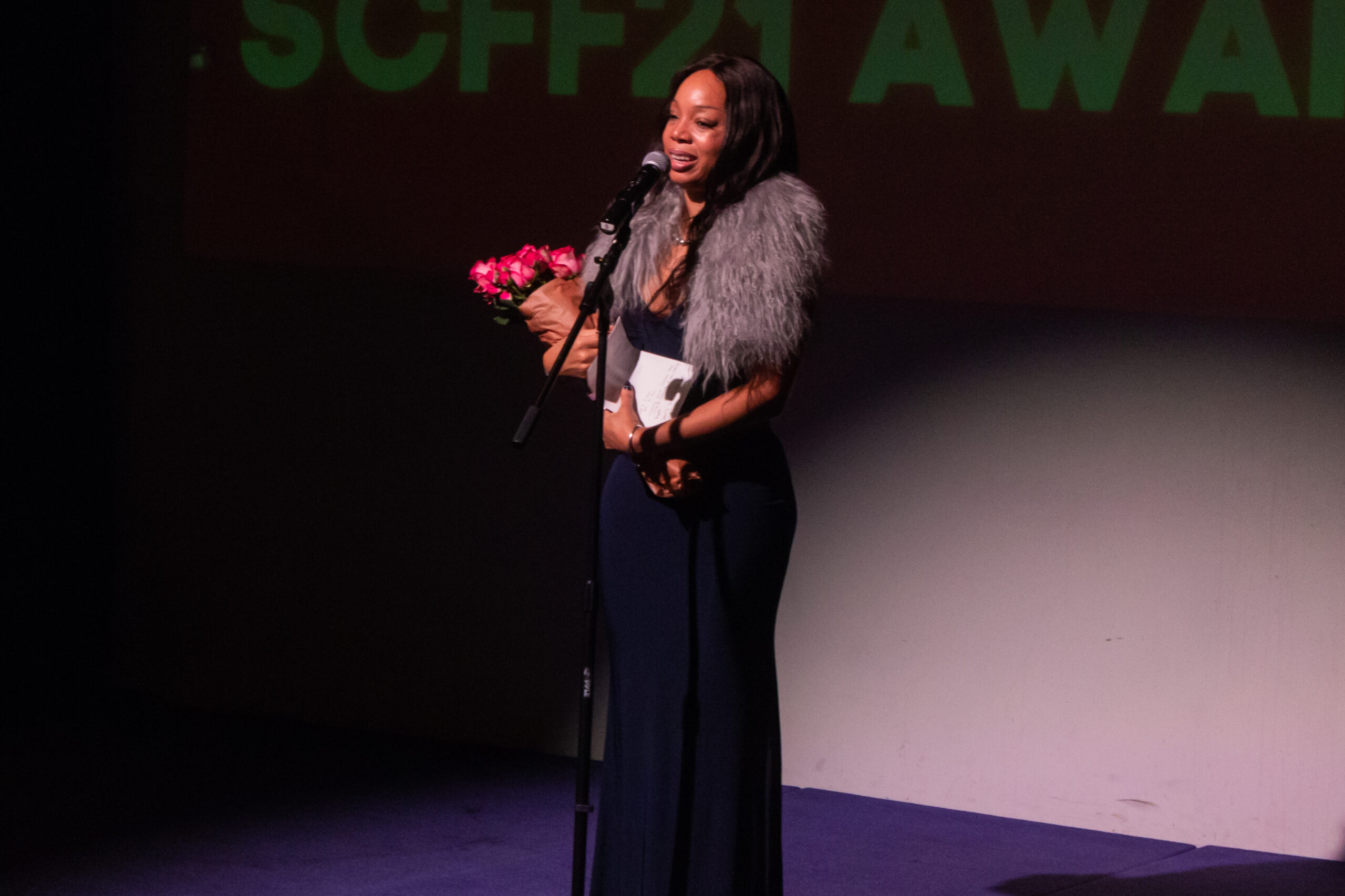 a woman standing on a stage with a microphone
