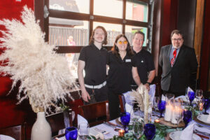 a group of people standing next to each other at a table