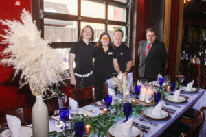a group of people standing around a table