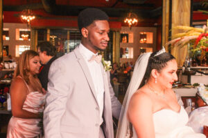 a bride and groom standing in front of a cake