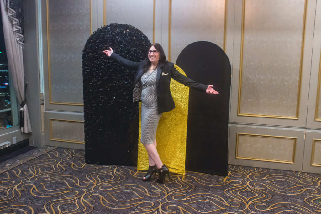 a woman standing in front of a black and yellow sculpture