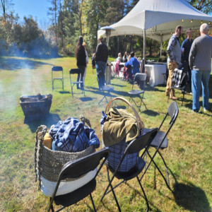 a group of people standing around a tent with smoke coming out of it