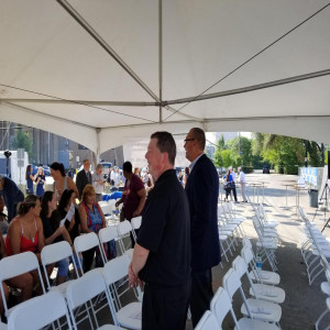 a couple of men standing next to each other under a tent