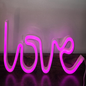 a neon sign that says love on a table