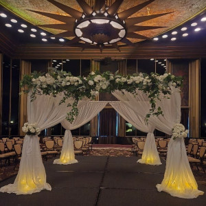 a wedding ceremony setup with white flowers and draping