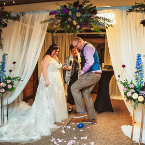a man and woman standing in front of a wedding arch