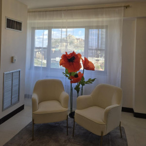 a living room with two chairs and a vase of flowers