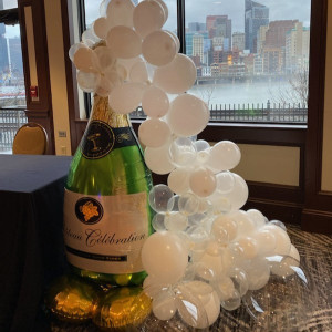 a bottle of champagne and balloons on a table