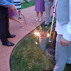a group of people standing around a bucket with sparklers in it