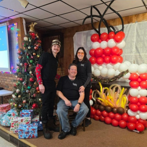 a group of people standing in front of a christmas tree