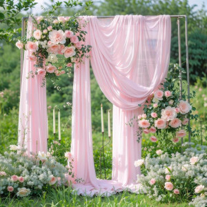a pink wedding arch decorated with flowers and greenery