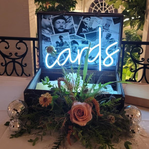 a table topped with a box filled with flowers