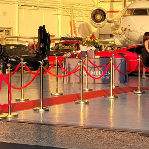 a woman sitting on a red carpet in front of an airplane