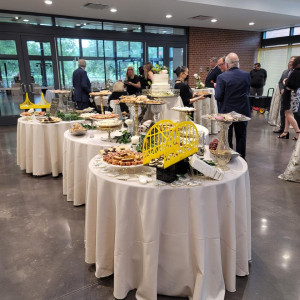 a group of people standing around a table filled with food