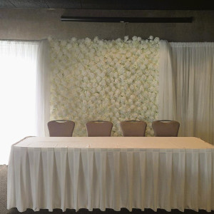 a long table with chairs and a white backdrop