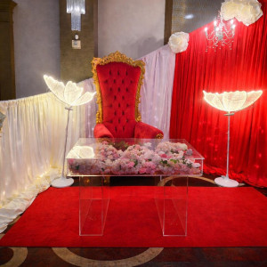 Bellissima Curve curved draping backdrop with red velvet throne and acrylic table at a luxury Pittsburgh event
