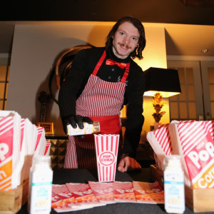 a man in an apron standing next to a table filled with boxes of food