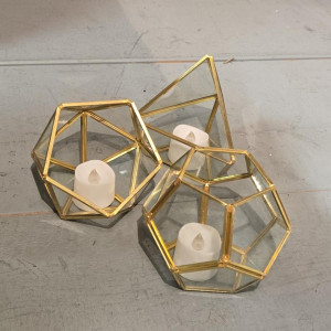 Set of gold geometric terrarium tea light holders with glass panels styled on a modern wedding reception table