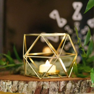 Gold geometric hexagon terrarium tea light holder with glass panels glowing on a wedding reception table in Pittsburgh