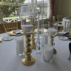 a table with a white table cloth and gold candlesticks