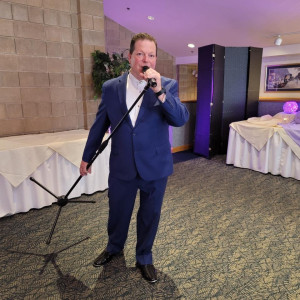 a man standing in a room holding a microphone