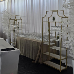 a room with a table, chairs, and a display of wine glasses